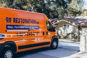 911 water damage restoration van parked outside of house